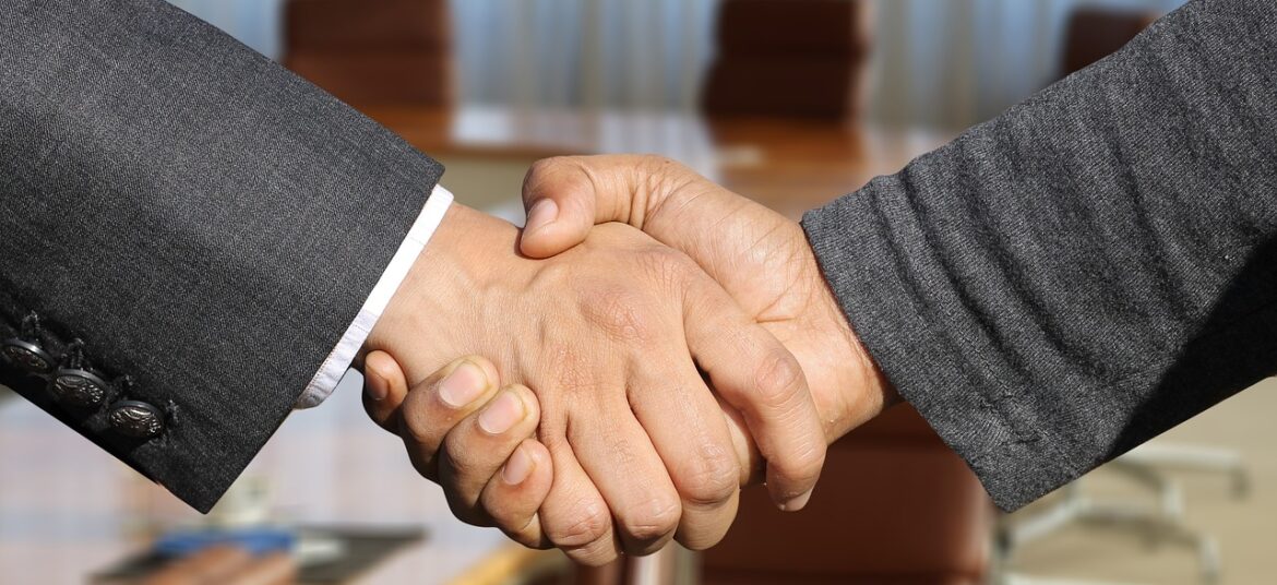 Handshake zwischen interner HR-Managerin und externem Recruitment-Spezialisten im Büro, dies zeigt erfolgreiche Zusammenarbeit durch Recruitment as a Service (Raas)